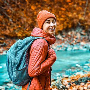 environmental science student hiking near stream