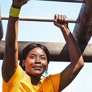 female health science student climbing across monkey bars